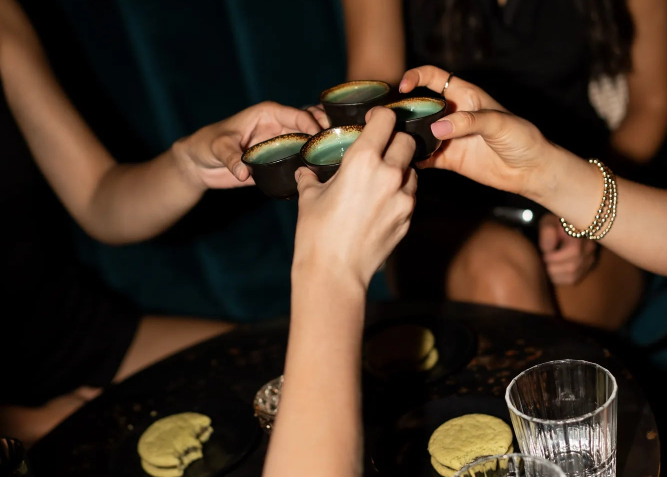 Four women celebrating an engagement with shots and Royce+Reign Margarita cookies.
