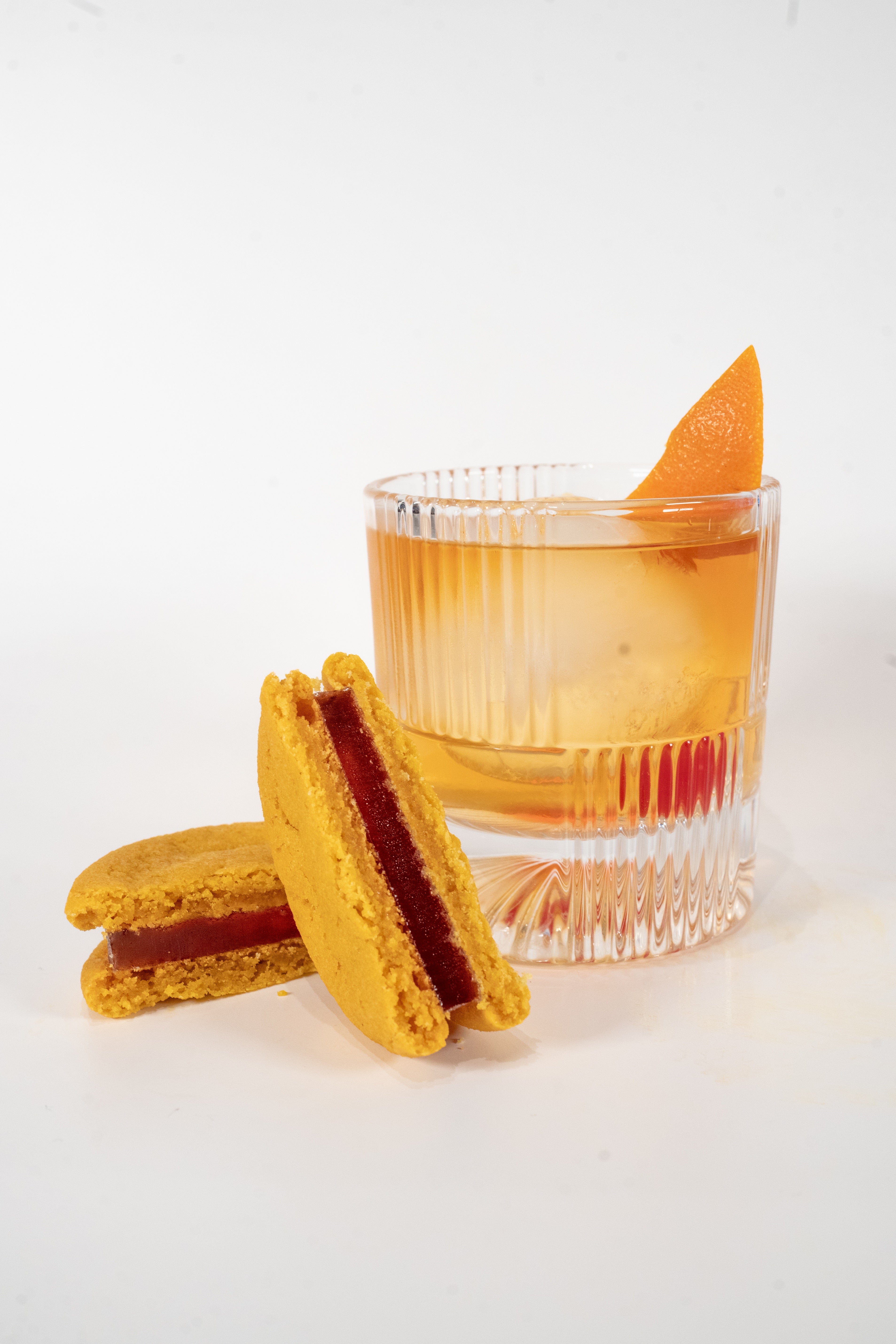 Old Fashioned Cocktail glass next to a Royce+Reign zero-proof event favor cookie