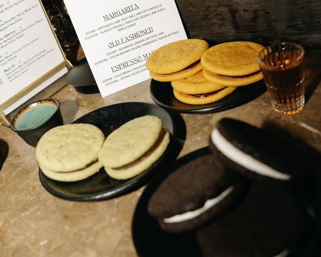 Three plates of cookies showcasing the three conctail-inpired, zero-proof event favors that Royce+Reign offers in their Cookie Flight bundle.