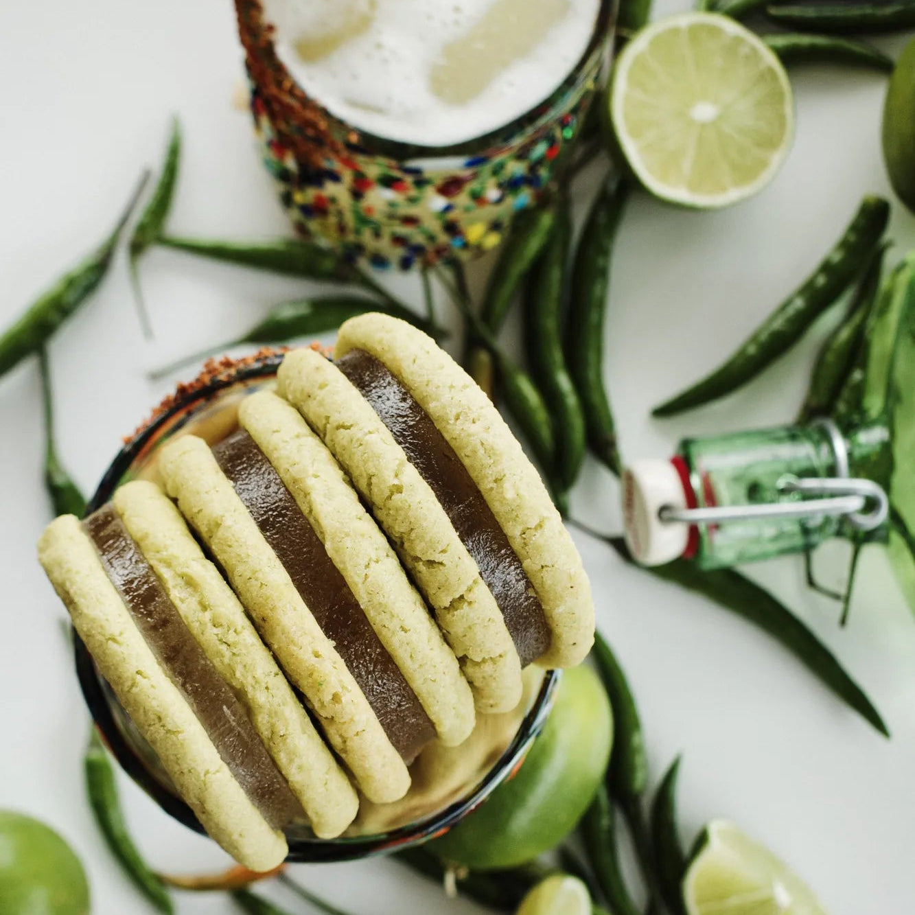 Three Royce + Reign margarita cookies next to a Lime Margarita representing the perfect premium event favors.
