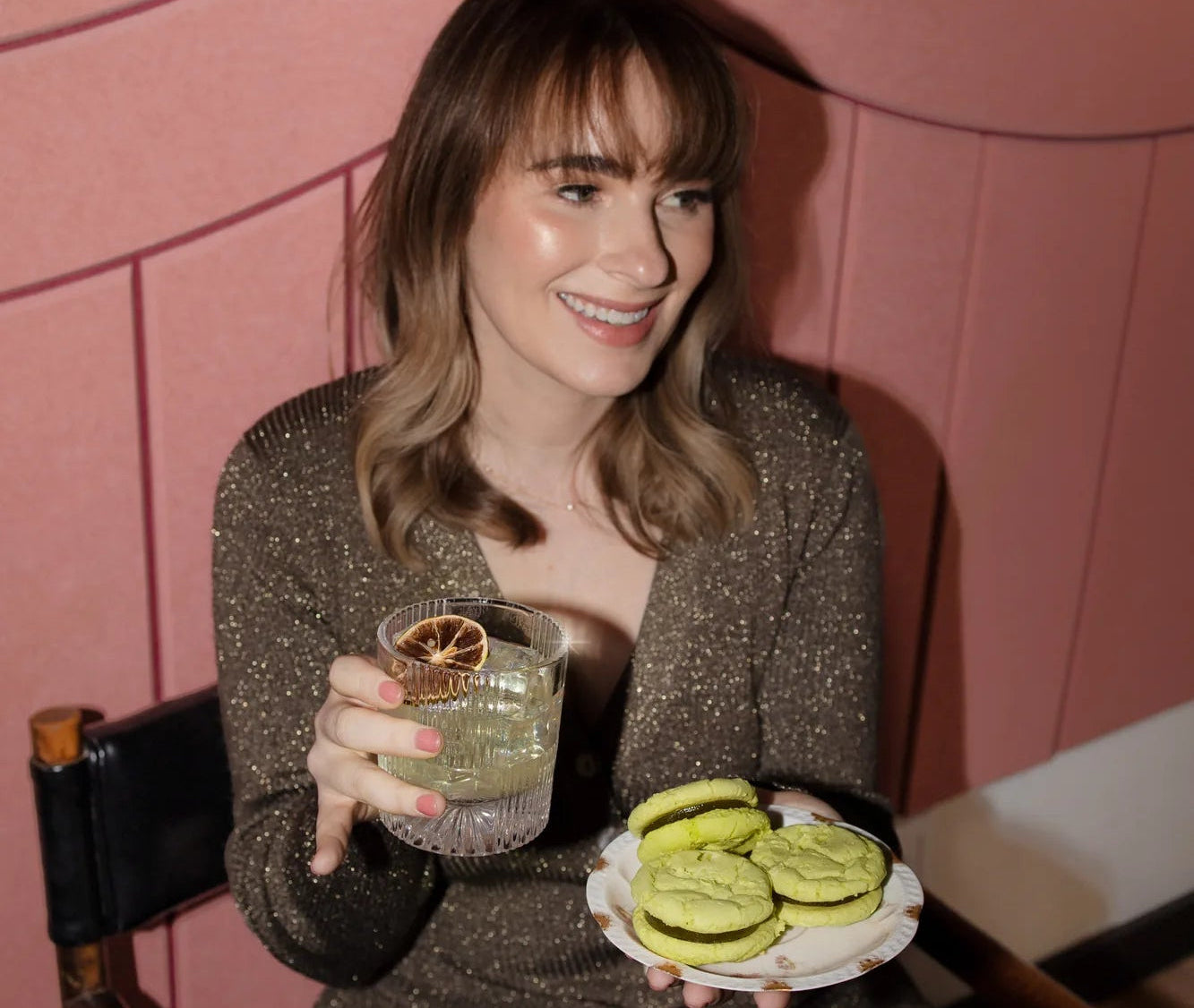Founder of Royce + Reign holidng a lime margarita and a plate of cocktail-inspired, zero-proof Margarita cookies.